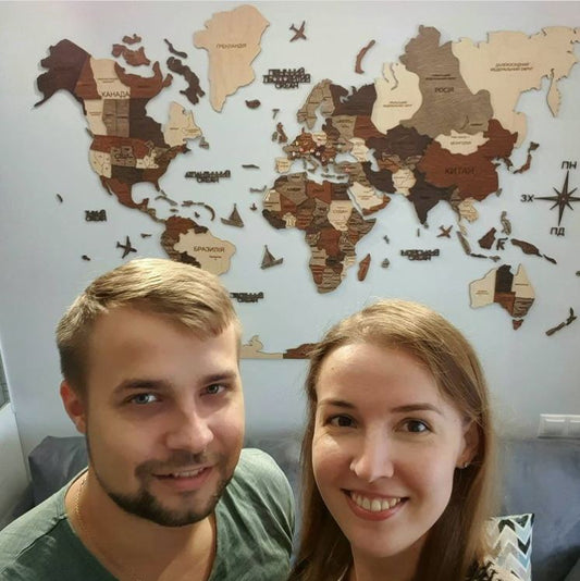 A Couple in Front of their 3D Wooden World Map in Multicolor