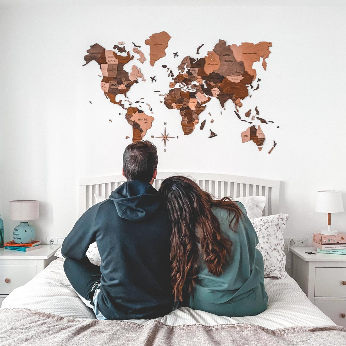 A Couple Staring at their 3D Wooden World Map in Multicolor